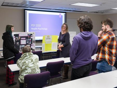ACC Psychology students presenting projects in classroom with faculty member Amy Wilkerson