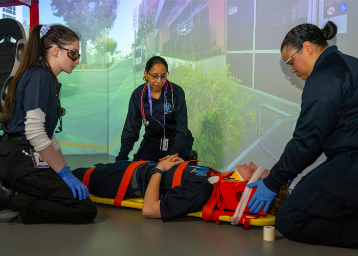 ACC EMS students in a simulation exercise placing classmate on stretcher.