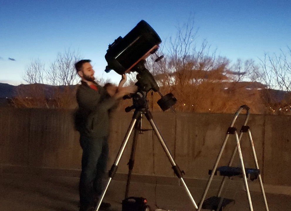 ACC student looking into large telescope at the Littleton Campus.