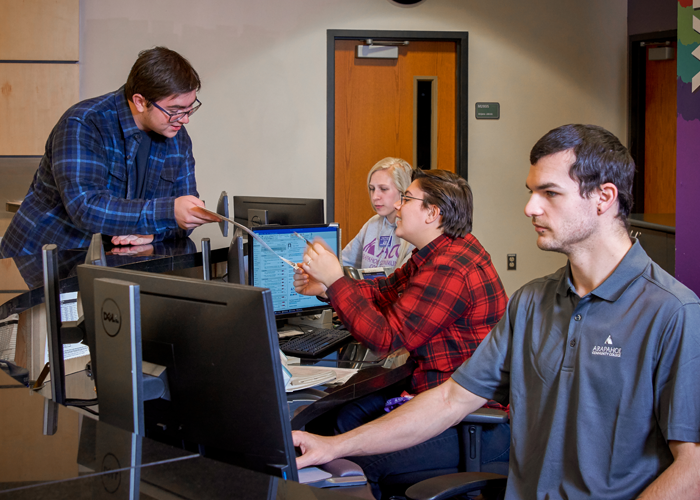 ACC student getting assistance at the Welcome Center as employees work on computers - Littleton Campus.