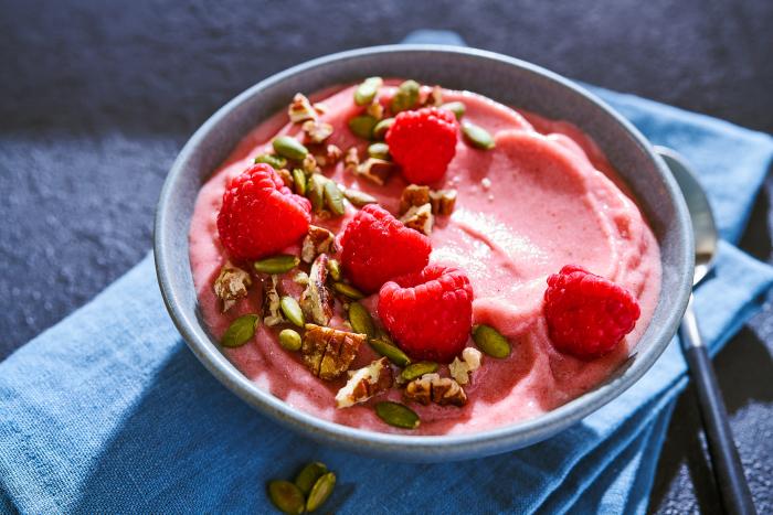 Bowl of raspberries and granola in. yogurt on a napkin - photo by Kate Blakeman