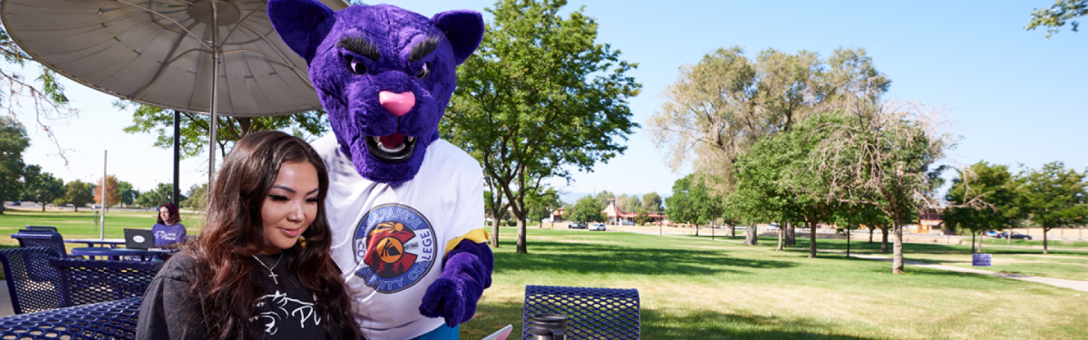 ACC student with the puma mascot on the west patio at the Littleton Campus.