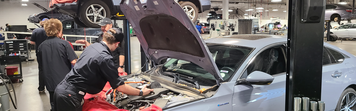 ACC auto apprentices working on a gray car at the Littleton Campus.