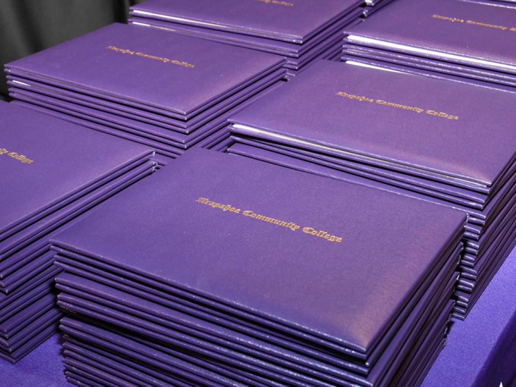 Stacks of Arapahoe Community College diplomas.