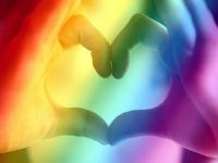 rainbow over hands shaped into a heart