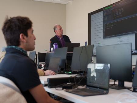 An instructor teaches students Java computer coding.