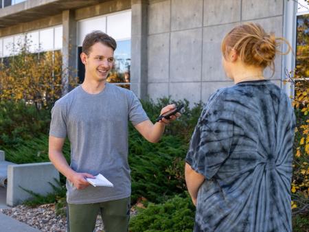 ACC Journalism student interviewing an ACC student outside of the main building at the Littleton Campus.