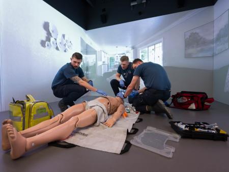 3 ACC EMS/Paramedic students practice resuscitation skills on a manikin on the floor in the new facilities at the Littleton Campus.