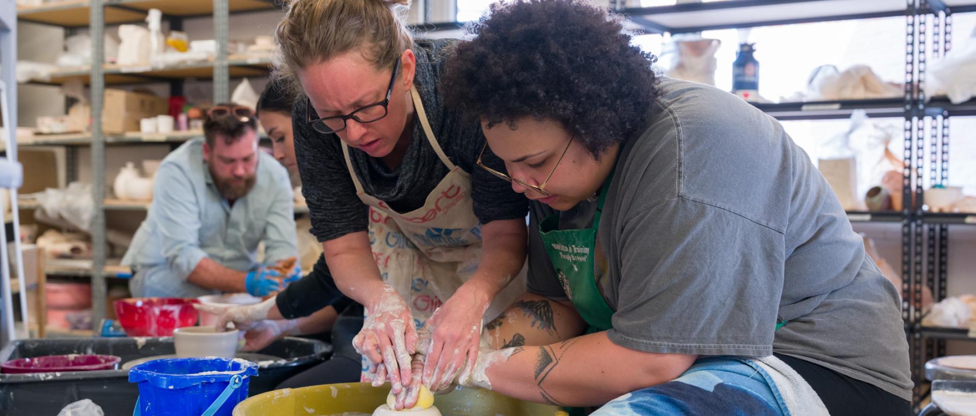 ACC Art faculty working with a student on the ceramics wheel at the Art & Design Center.