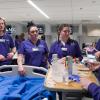 Four ACC Nursing students practicing skills around a hospital bed in a classroom at the Littleton Campus in the Health Innovation Center