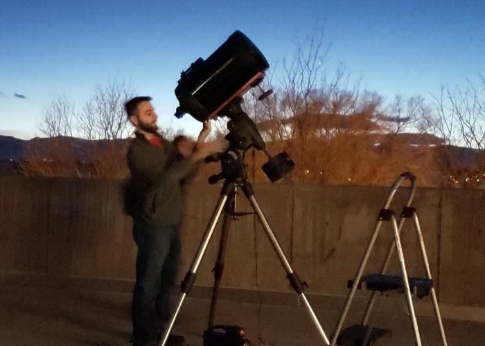 ACC student looking into large telescope at the Littleton Campus.