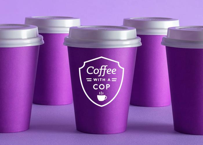 Coffee with a Cop - several purple disposable coffee cups with white lids