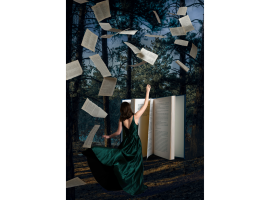 Woman in front of book with pages flying in forest (photo by Meagan Harkin)