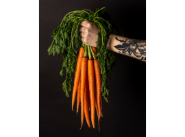 Hand holding a bunch of carrots (photo by Mercedes Peterson)