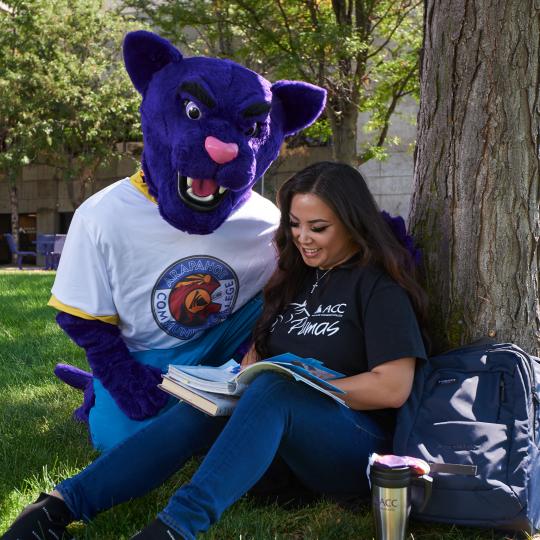 ACC Puma with student reading under a tree at the Littleton Campus.