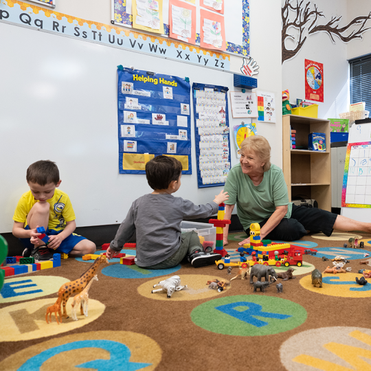 ACC early childhood educator in a classroom with students at the Child Development Center at ACC's Littleton Campus.